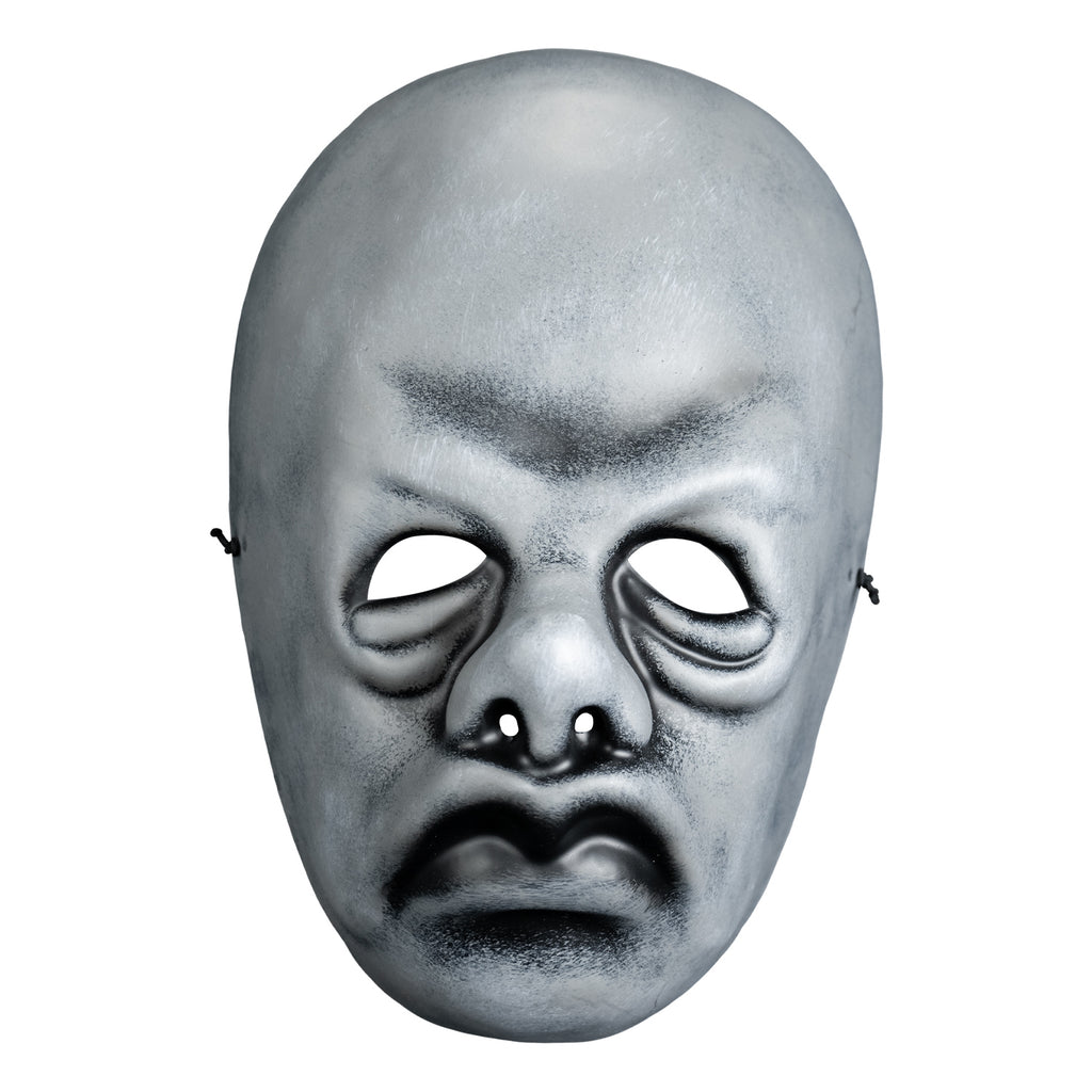 Mask, front view. Black and white toned face mask. Bald, no eyebrows, bags under eyes, pug nose, mouth in a frown with prominent lips.