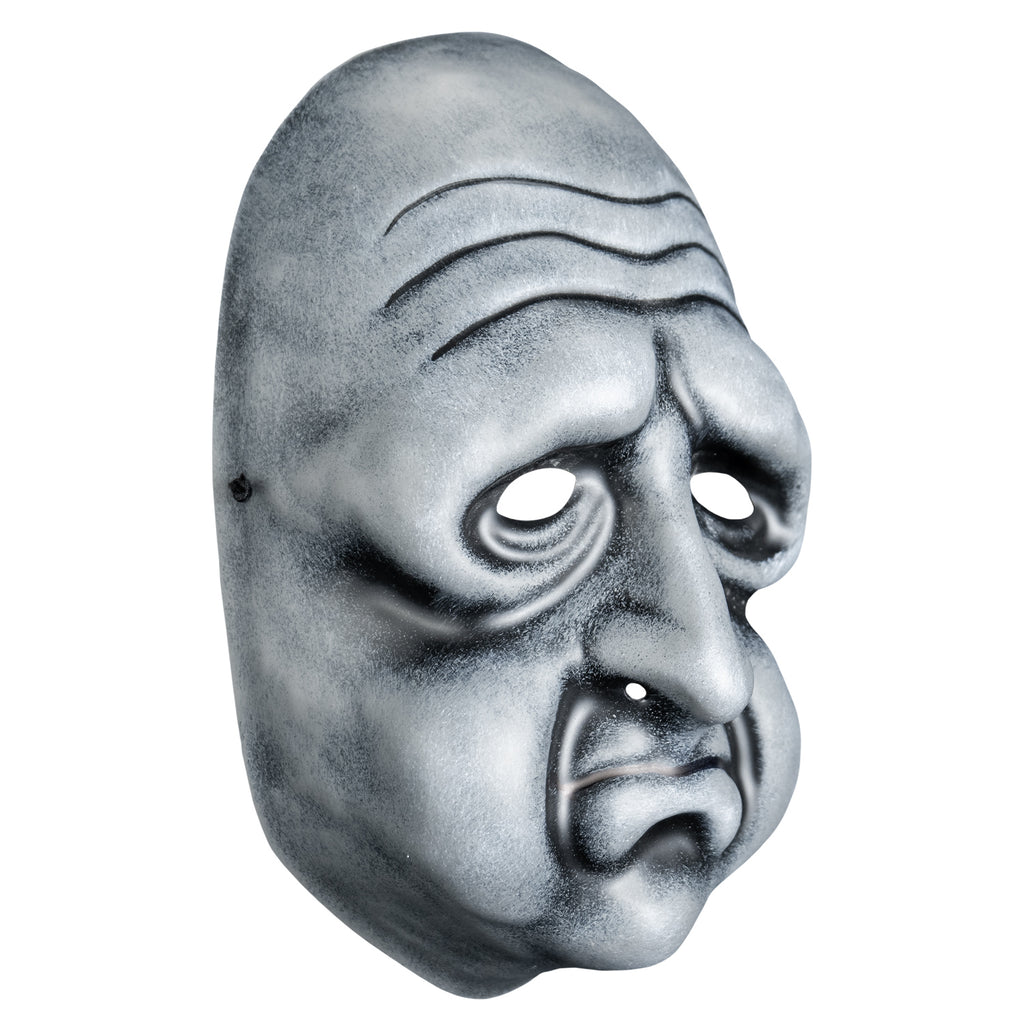 Mask, right view. Black and white toned face mask. Bald, wrinkles on forehead, no eyebrows, bags under eyes, long nose, round cheeks and chin, mouth in a frown with prominent lower lip .