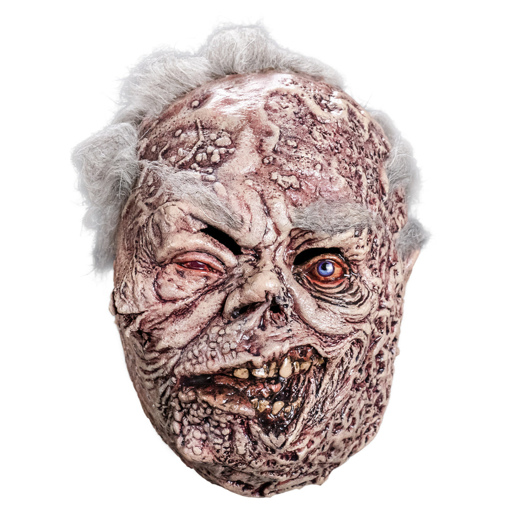 Mask, front view.  sparse short white hair, bushy white eyebrows.  Mottled, wrinkled and sagging white and brown skin. Right eye squinting almost shut and watery. Bloodshot, open blue left eye.  small deformed nose.  Crooked rotting mouth, sagging bottom lip, slightly open showing some crooked and dirty teeth