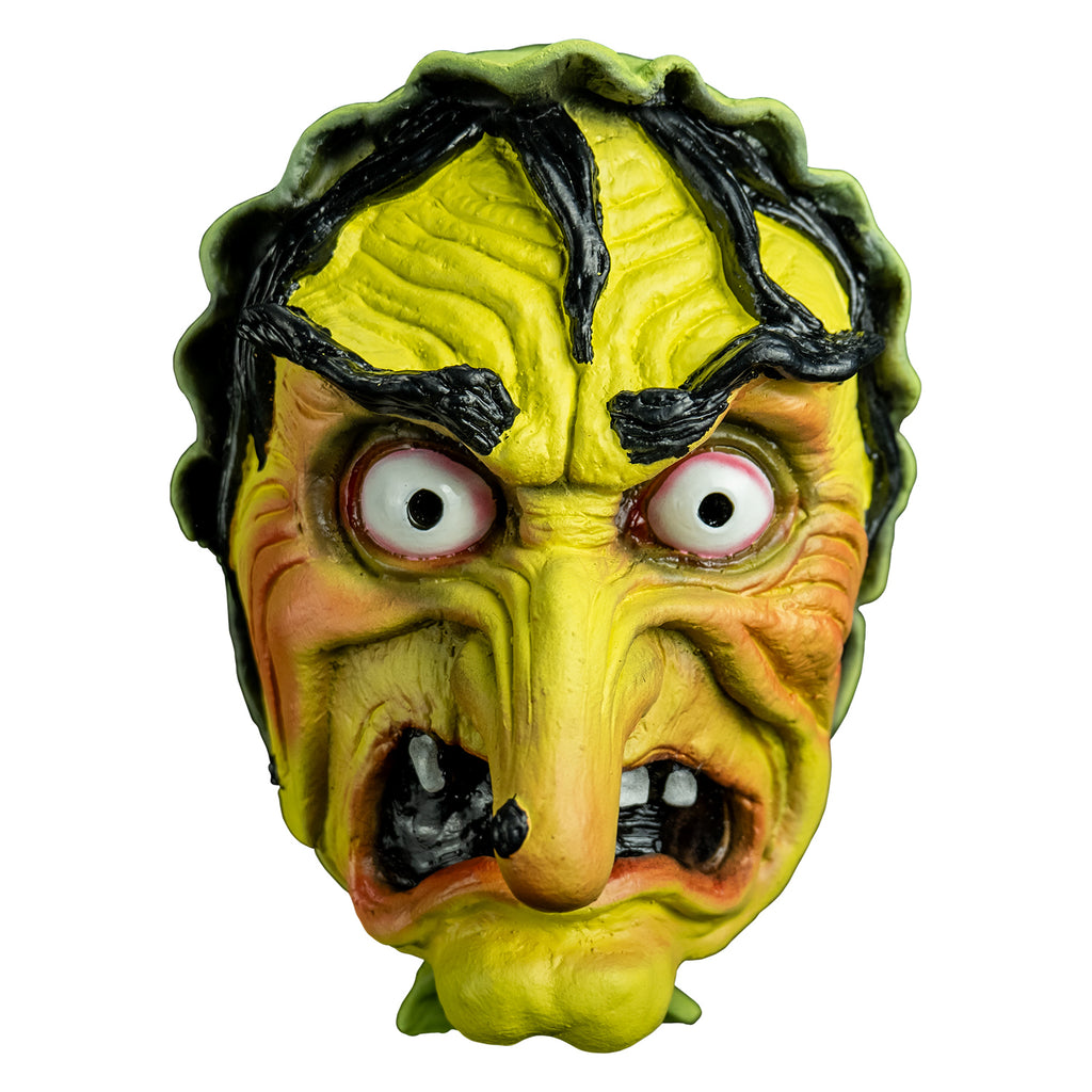 Mask front view.  yellow-green wrinkled flesh, wearing a green bonnet, stringy black hair and eyebrows, large red-rimmed white eyes, long pointed nose with a black wart, open grimacing mouth showing gapped white teeth.
