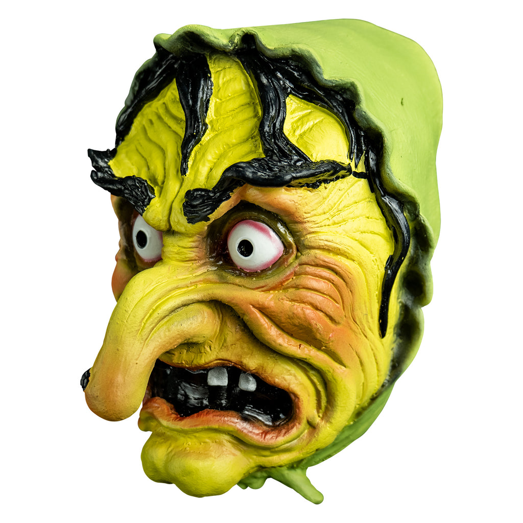 Mask left view. yellow-green wrinkled flesh, wearing a green bonnet, stringy black hair and eyebrows, large red-rimmed white eyes, long pointed nose with a black wart, open grimacing mouth showing gapped white teeth.