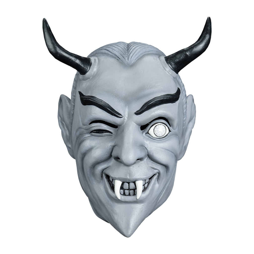 Mask, front view. Black and white toned. Gray slicked-back hair, black horns on forehead, Black eyebrows, dark slightly closed right eye, left eye wide open, smiling mouth, two white fangs.