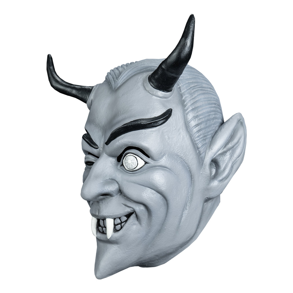 Mask, left view. Black and white toned. Gray slicked-back hair, black horns on forehead, Black eyebrows, dark slightly closed right eye, left eye wide open, smiling mouth, two white fangs.