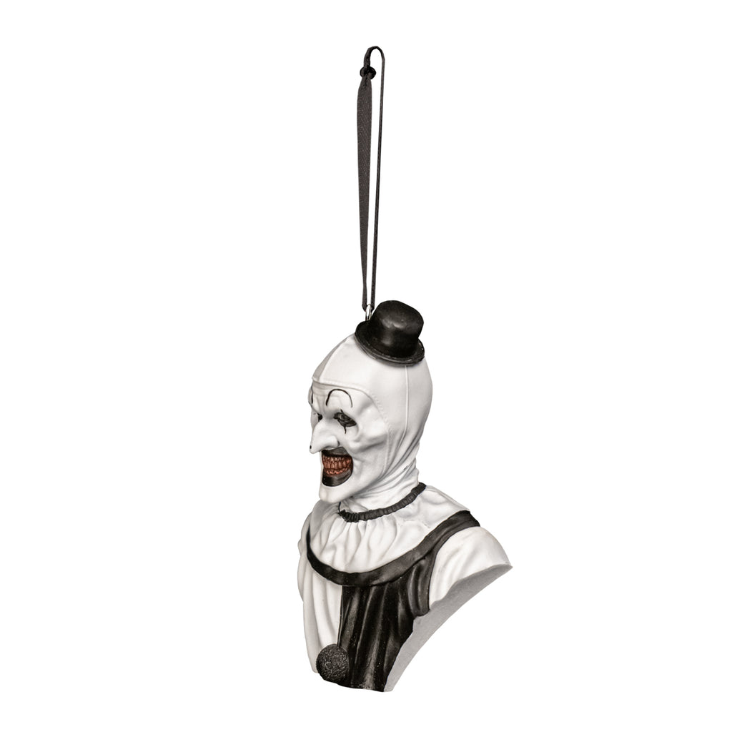 Ornament, bust, head, neck and upper chest, left view. Evil grinning, black and white clown face, high black painted eyebrows, black around eyes and mouth, black dot on tip of nose, pink gums and yellow teeth. wearing tiny black top hat and black and white clown suit with ruffled neck and a black pompom on chest.