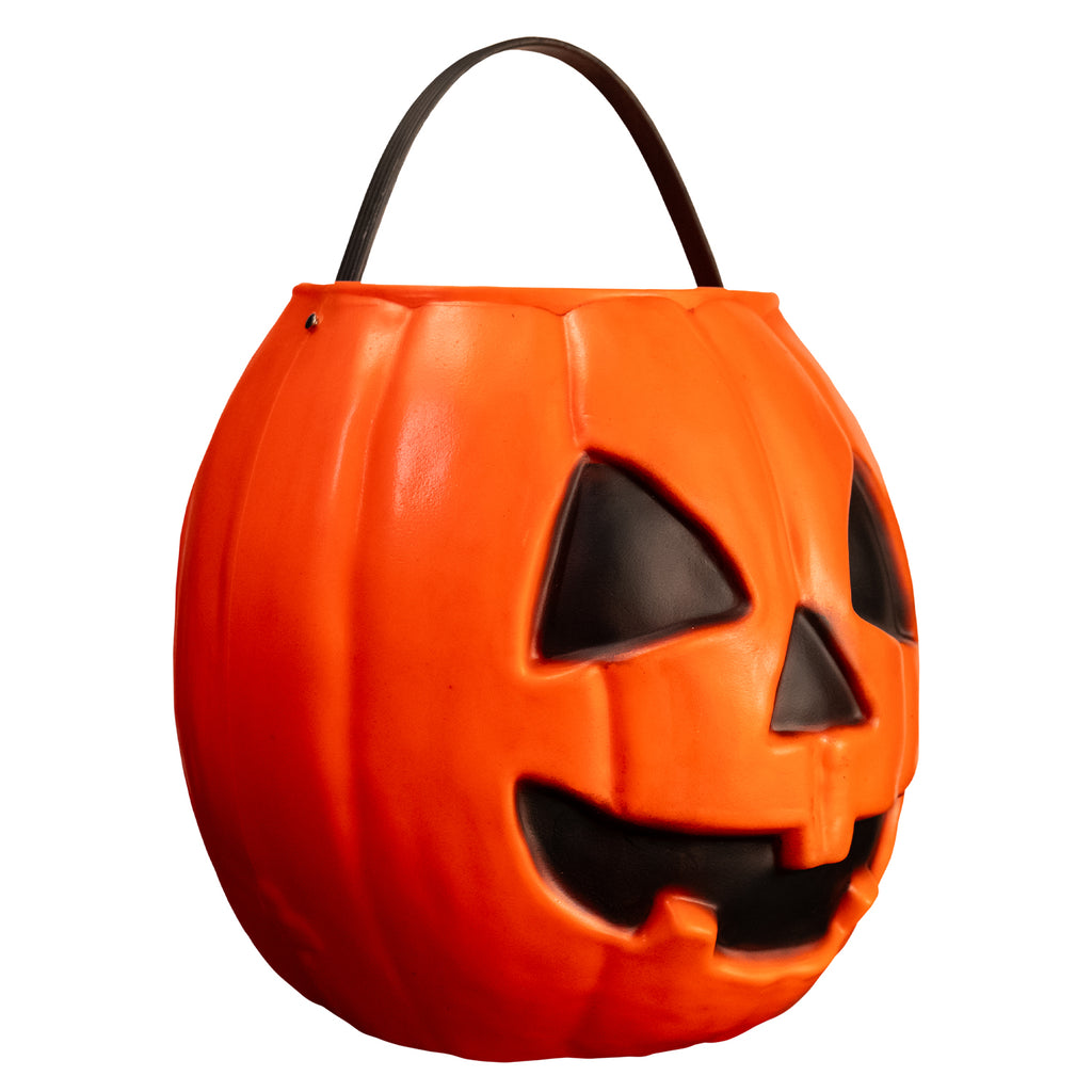 right view pumpkin candy pail. Orange Jack o' lantern face. black eyes nose and face. Black handle at top.