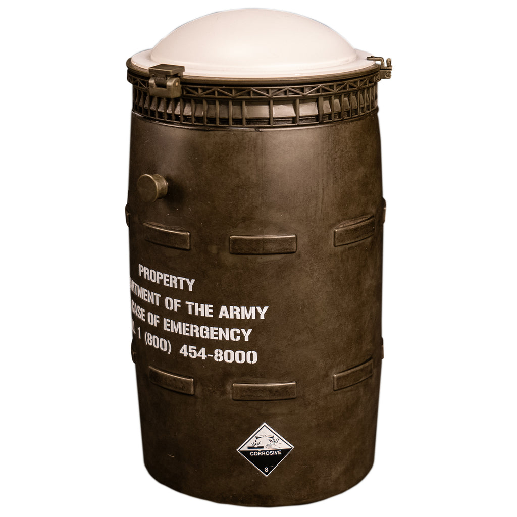 side view Black barrel with white lid, white text reads property of the army in case of emergency call 1 800 454-8000.