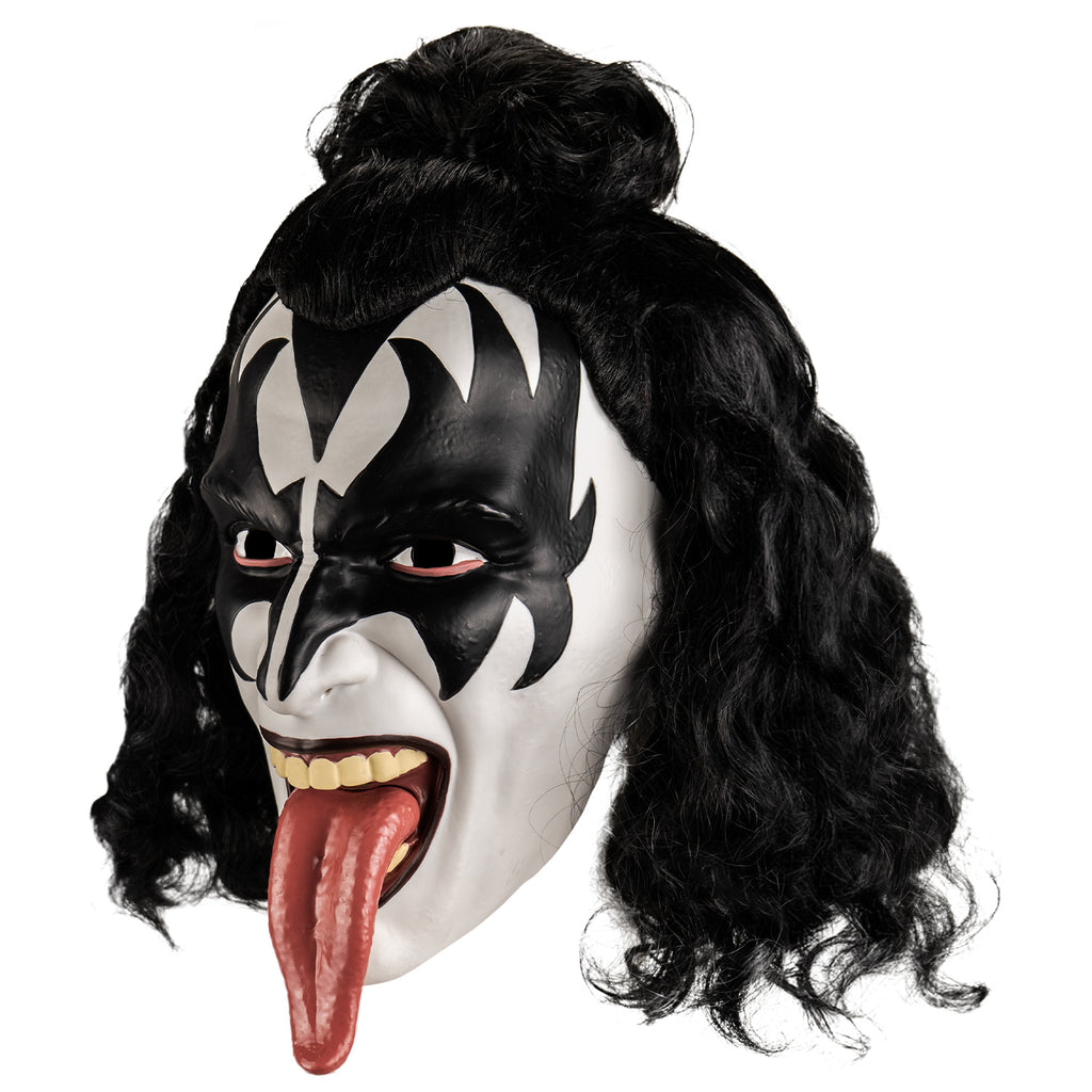 Kiss plastic mask left view. Black curly hair, front half in a bun at the forehead. White face, black painted widow's peak on forehead, black painted demon wings over eyes forehead and cheeks. Black lips, mouth wide open showing upper teeth and long tongue hanging out.