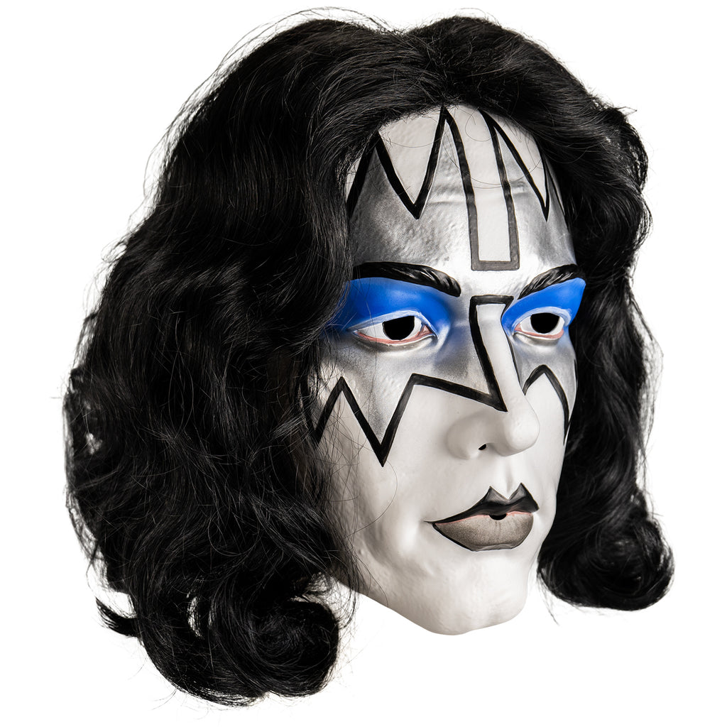 Kiss Spaceman plastic mask right view. Long black hair, white face, Black eyebrows, blue eyeshadow on eyelids, surrounded with silver painted angular shapes outlined in black from the edges of the forehead to the cheekbones, black and gray painted lips.
