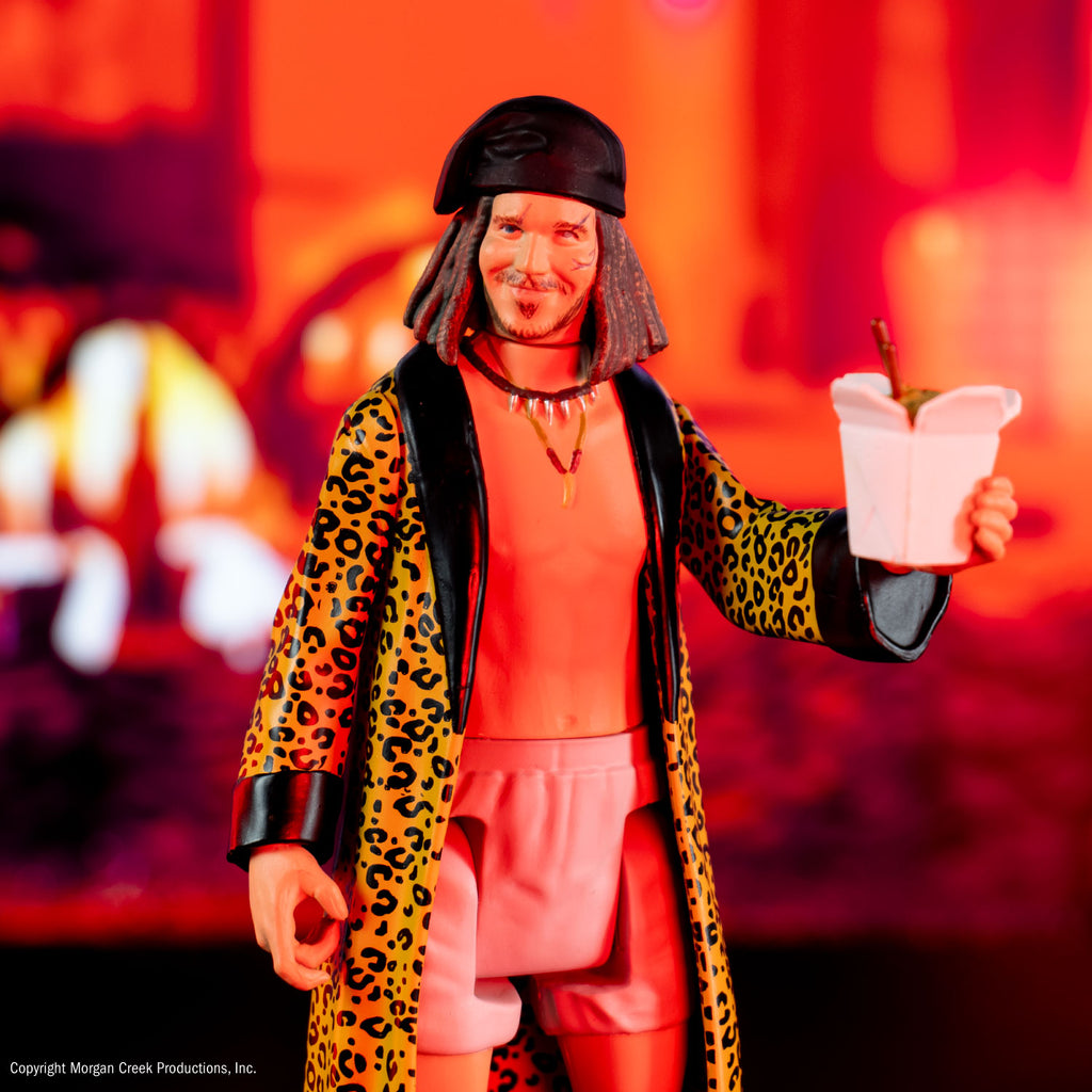 Drexel figure, glam shot red-orange lighting. Man shown from knees up, scars on face, shoulder length brown hair, black bandana on head, thin mustache and beard with soul patch, wearing two necklaces, white boxer shorts, yellow cheetah print robe with black trim, no shirt.  Chinese food takeout box with food and chopsticks inside, in left hand.