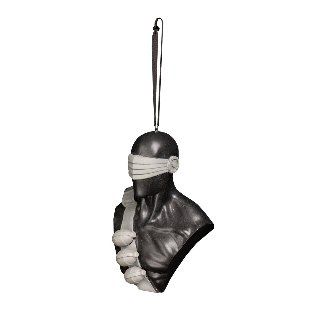 ornament, left side view. Bust of G I Joe Snake Eyes, head shoulders and chest. Wearing skin-tight metallic black suit, gray visor over eyes nose and ears, black ammunition band across chest with 3 hand grenades. Black cord at top for hanging.