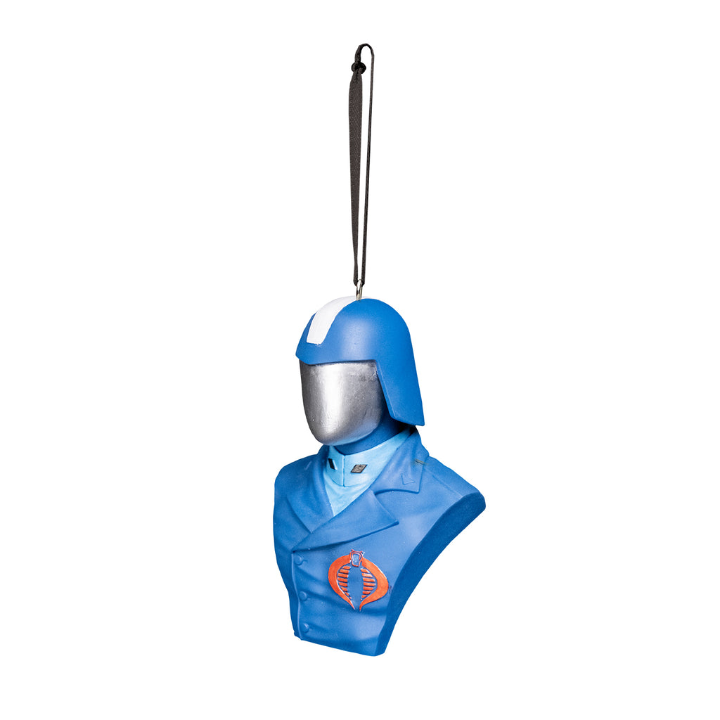 ornament, left view. Bust of Cobra Commander, head shoulders and chest. Wearing blue helmet with wide silver stripe in the center, silver face shield. blue asymetrical buttoned uniform jacket with red cobra emblem on left breast, light blue high-collared shirt underneath. Black cord at top for hanging.