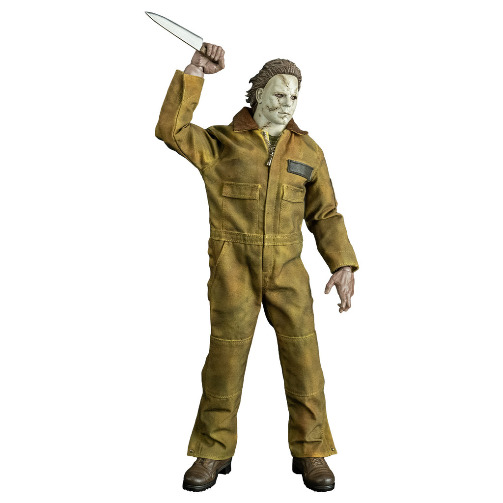 Front view, Michael Myers 1:6 scale action figure. Wearing Halloween 2007 mask, tan coveralls, brown boots. holding kitchen knife in raised right hand.