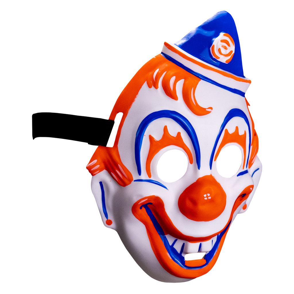 Face mask, right side view. white clown face, blue white and orang triangular hat tipped to the left . orange painted hair. Blue arches around eyes, orange painted eyelashes, blue lines on cheeks and ears, orange dots on earlobes, large orange clown nose. Orange and blue clown mouth in a large smile showing teeth. Black elastic strap at temples