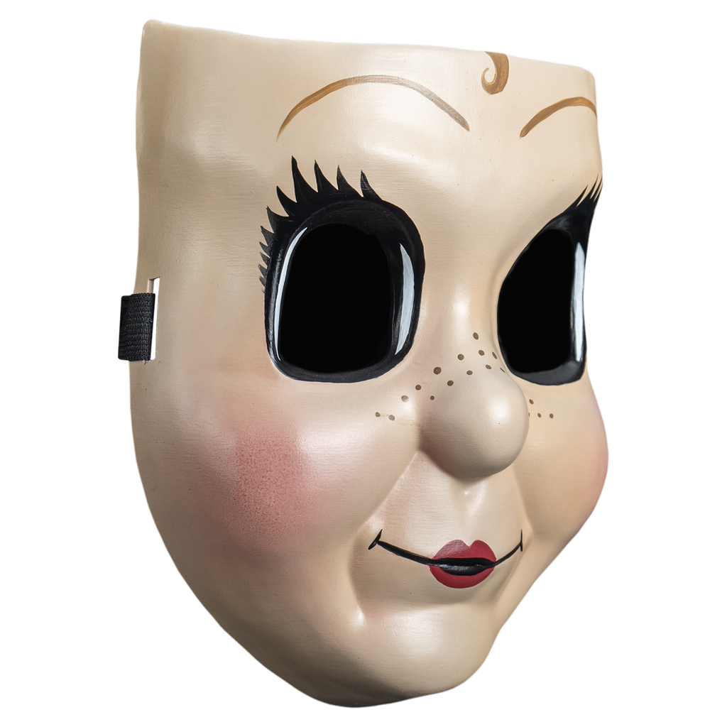 Plastic face mask, right view.  Dollface, Small light brown curly painted in the center of the forehead, large empty black eyes with spiky eyelashes. Thin brown eyebrows. Freckles on nose and cheeks, smiling mouth with small red lips. Plump pink cheeks.