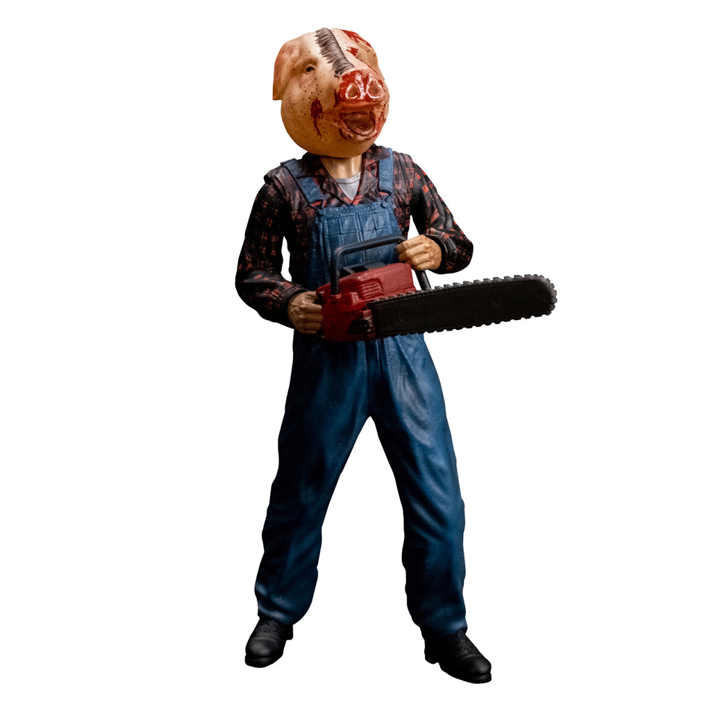 8 inch figure, slight right view.  Person with bloodied pig head mask, mouth open.  Wearing flannel print shirt, blue overalls, black boots.  Holding red chainsaw with both hands.