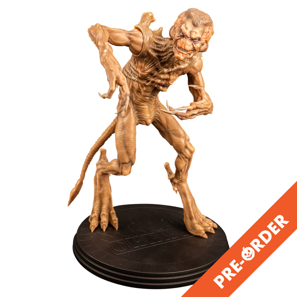 White background. Orange diagonal banner bottom right, white text reads pre-order.  Slight right view Pumpkinhead 8" scale figure.Pale orange tan creature with enlarged upper head. White eyes, animal-like muzzle,  mouth showing sharp yellow teeth. Bony with defined muscles, protrusions on shoulders,  long limbs and tail.  Hands have 4 long fingers and claws.  Animal-like 3 toed feet with bony protrusions on heels, short claws.  standing on black round platform.  