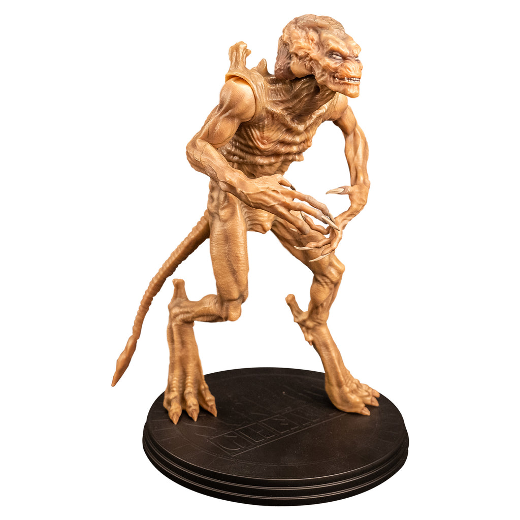right side view Pumpkinhead 8" scale figure.Pale orange tan creature with enlarged upper head. White eyes, animal-like muzzle, mouth showing sharp yellow teeth. Bony with defined muscles, protrusions on shoulders, long limbs and tail. Hands have 4 long fingers and claws. Animal-like 3 toed feet with bony protrusions on heels, short claws. standing on black round platform.