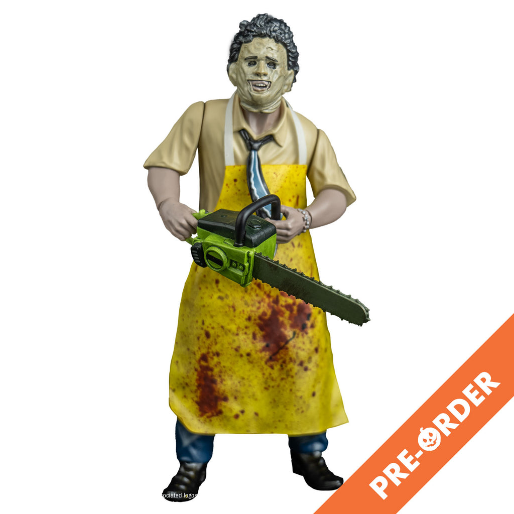 white background, orange diagonal banner at bottom right corner, white text reads Pre-order. Leather face action figure, front view. wearing killing mask, short brown bushy hair, black eyebrows, skin is sewn together, stitches around forehead and ears, open space for mouth, tan button up short-sleeved shirt, black, blue and white necktie, yellow apron splattered with blood, blue pants and brown shoes. Holding a green bodied chainsaw in both hands, at waist level