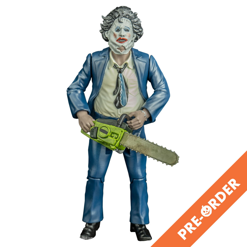 white background, orange diagonal banner at bottom right, white text reads pre-order.  action figure, front view. Leatherface, wearing pretty woman mask mask,  dark hair. stitches around upper right eye and across forehead, leather string tied at bottom sides of face. left eyebrow black, blue eyeshadow, pink blush on cheeks, red lipstick on mouth. Wearing blue suit coat and pants, white collared shirt, black blue and white necktie, black shoes. Holding yellow bodied chainsaw in both hands.