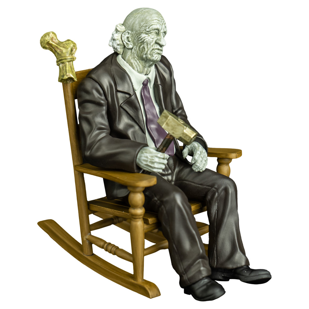 Grandpa figure, right side view. old man, gray skin, bald, gray skin, wearing a suit and tie, holding a hammer in right hand sitting in rocking chair with bones tied to the back.