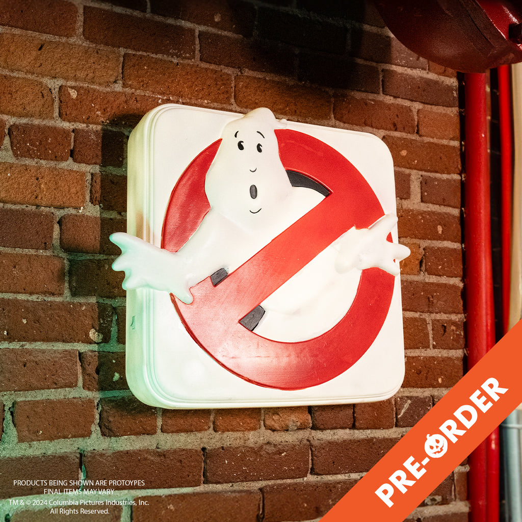 red brick wall background, orange diagonal banner at bottom right, white text reads pre-order. White square light up sign mounted on wall. White ghost in red crossed circle.