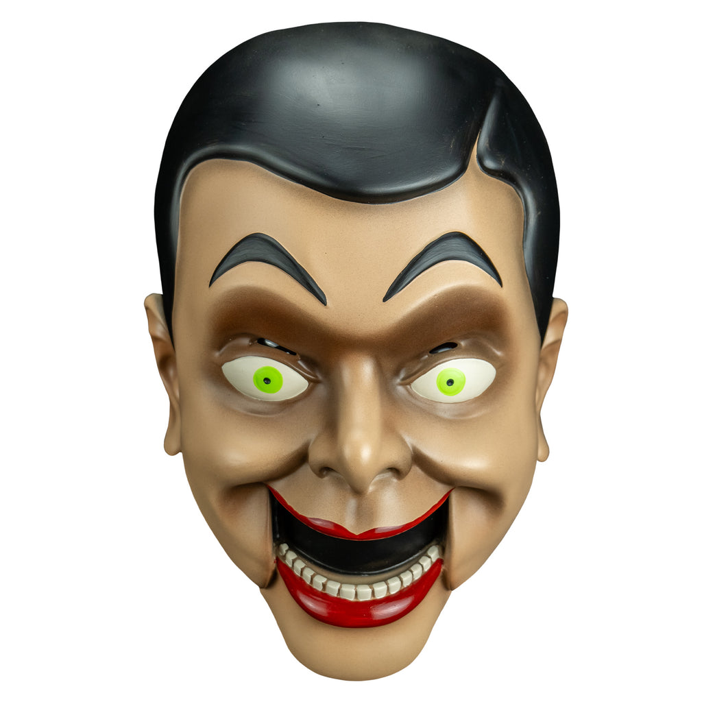 mask front view. Ventriloquist dummy face, black hair and eyebrows, large yellow green eyes, bright red lips, open hinged dummy mouth showing teeth.