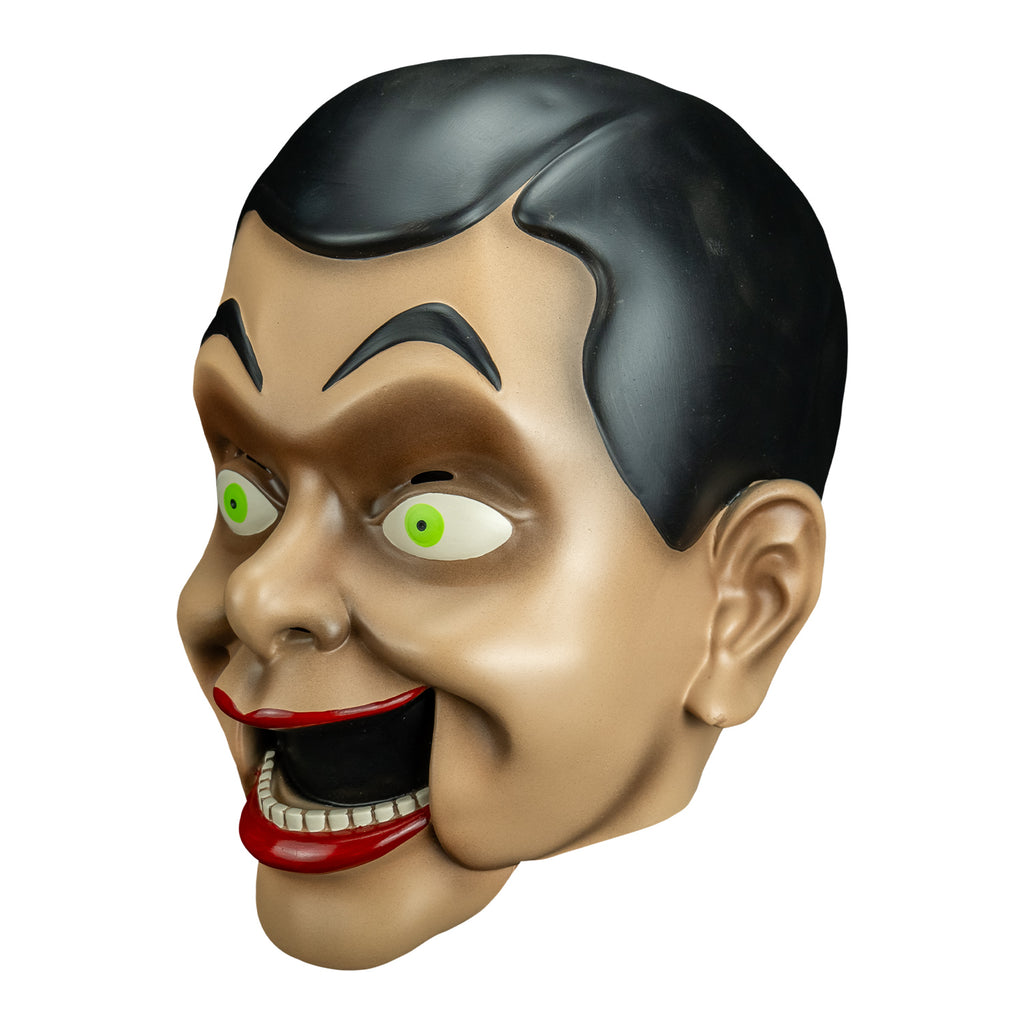 mask right side view. Ventriloquist dummy face, black hair and eyebrows, large yellow green eyes, bright red lips, open hinged dummy mouth showing teeth.