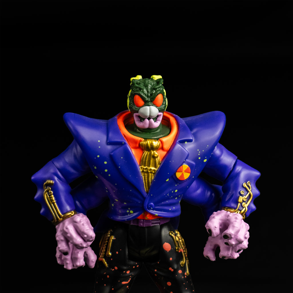 Black background. Action figure, front view closeup. Humanoid head removed Green bug head revealed green and yellow flesh, large orange eyes, white and pink mandibles. Wearing orange shirt with a gold tie, blue jacket, four arms, black pants with orange splatter.
