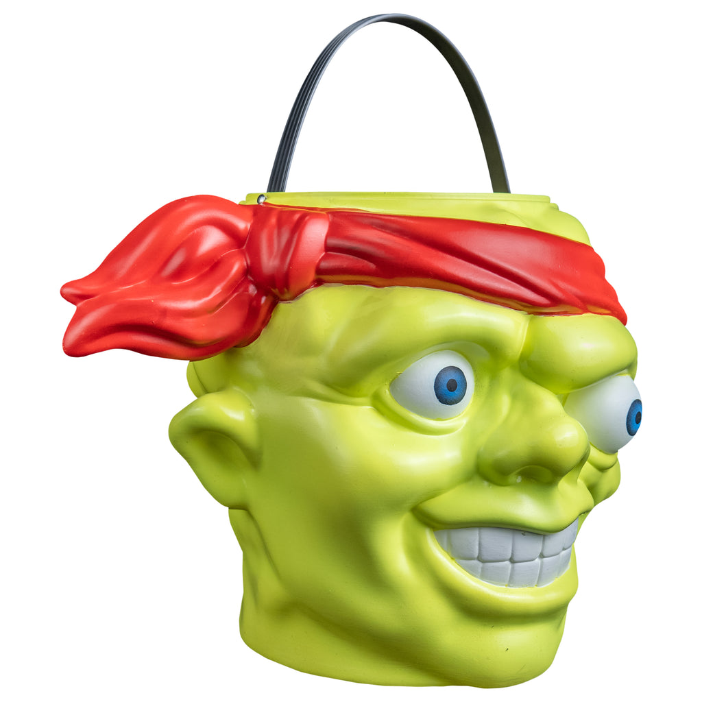 Candy pail, right side view. Bald head, green lumpy flesh, with red-orange headband tied around forehead. Misaligned blue eyes, crooked nose. Lips open showing large teeth. Green handle at top.