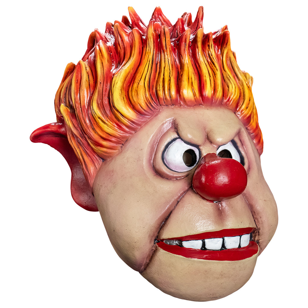 Mask, right side view. Cartoonish, round head, Yellow orange and red flame-like spiky hair, pointy red-tipped ears, furrowed brow, no eyebrows, large cartoon eyes, round red nose, prominent jowls, wide red-lipped mouth, slightly open showing large square white teeth.
