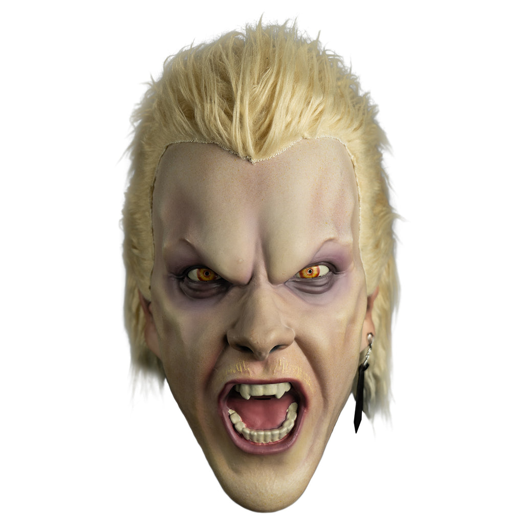 Mask, front view.  Light blond hair, slight mullet.  Furrowed brow, no eyebrows, dark circles under yellow eyes, long black earring in left ear, pale thin blond mustache,  mouth open in a snarl showing pink tongue and white teeth, fangs on either side of top two center teeth