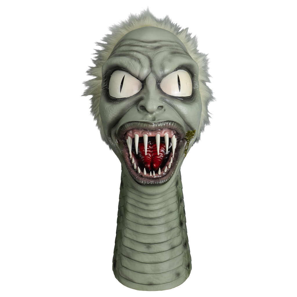 beetlejuice snake puppet, front view.  Gray flesh, spiky white hair on head, human-like face, wrinkled brow, large white eyes with vertical pupils.  Large mouth with gray and pink lips, wide open showing several sharp teeth in pink gums and a red forked tongue.  green crust on left corner of mouth.  long snake neck with horizontal scales.