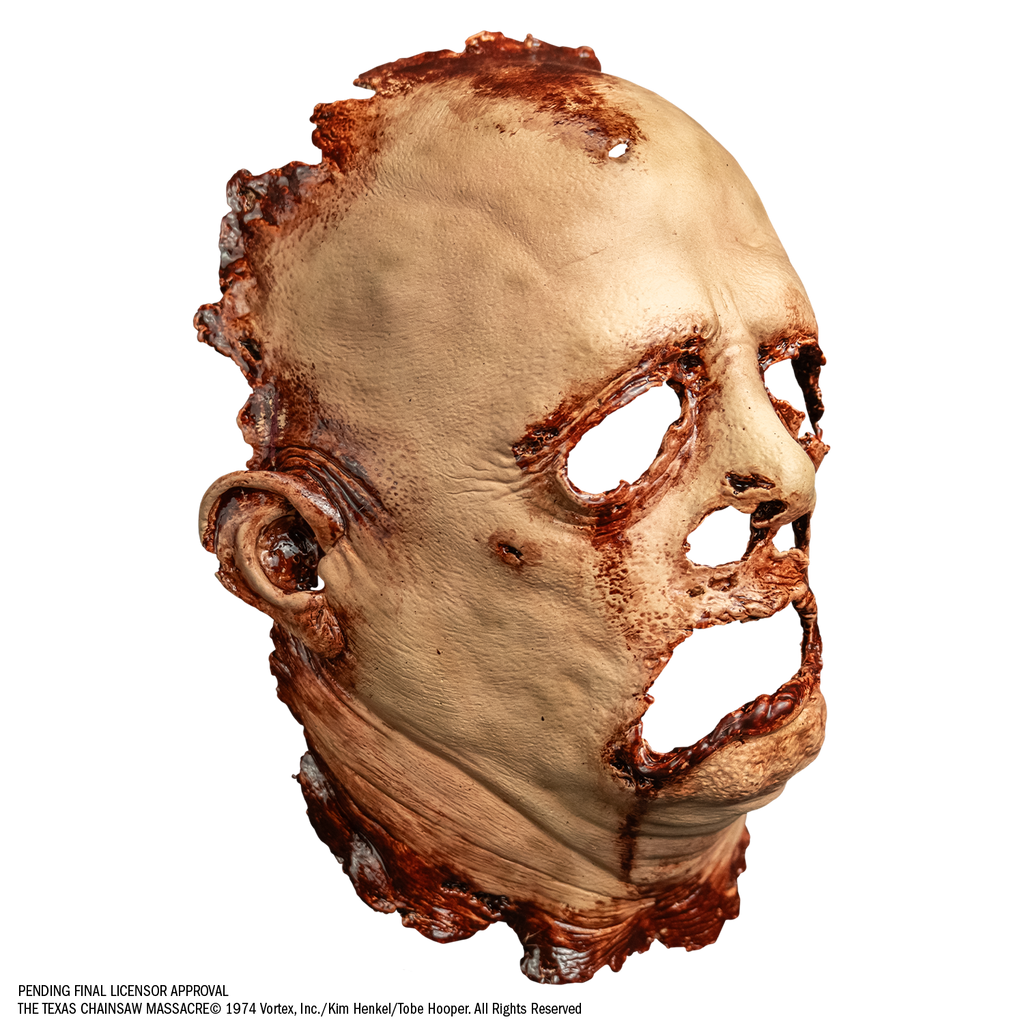 mask, right view. gory flesh, deformed facial features. only has the right ear. Bloody around margins of face and neck, eye, nose and mouth holes