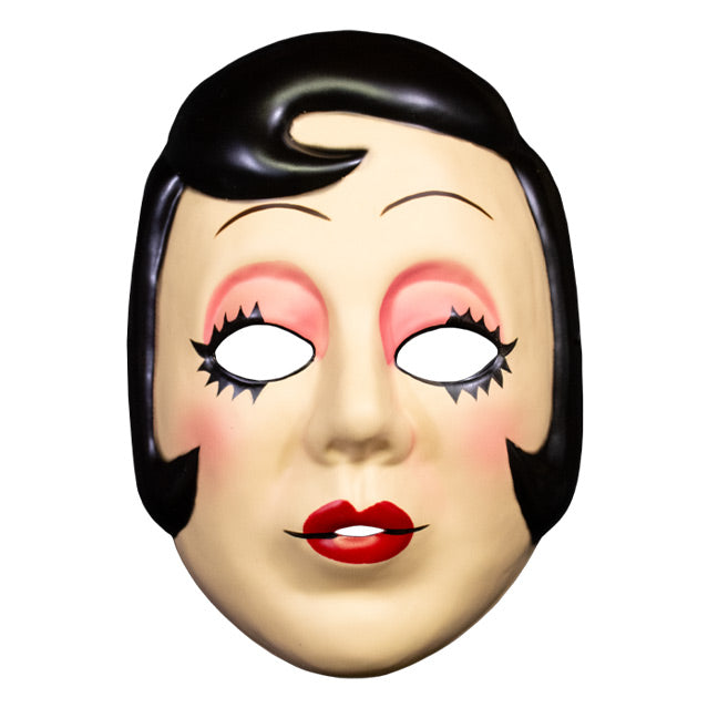 Plastic face mask, front view. Woman's face, short black hair with curl on right side of forehead and at cheeks. Thin penciled eyebrows, empty eyeholes, spiky black eyelashes, pink eyeshadow. Small round red lips.