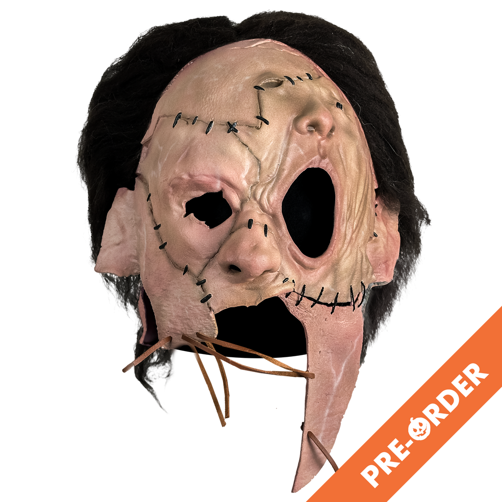 white background, orange diagonal banner at bottom right, white text reads pre-order. Mask, front view, short, dark brown, bushy hair, skin is sewn together, stitches around forehead, cheeks and ears, patch of skin over left eye and forehead is shaped like a nose and mouth. Lower face is open below nose with leather stitching across.