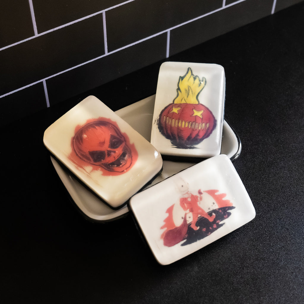 3 variations of soap, Sam unmasked, flaming jack o' lantern, Sam with bag and lollipop. Set in soap dish on black counter.