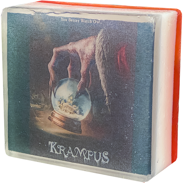 Bar soap. White, with illustration of a gnarled hand holding a snowglobe, white text at top reads You better watch out, text at bottom reads Krampus, under clear soap layer. 