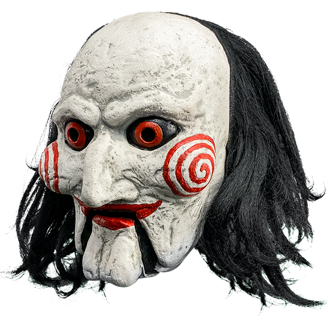 Mask, left side view. Saw Billy puppet, balding with black hair, white face, black-rimmed red eyes, red spirals on cheeks, red lips on hinged ventriloquist dummy mouth.