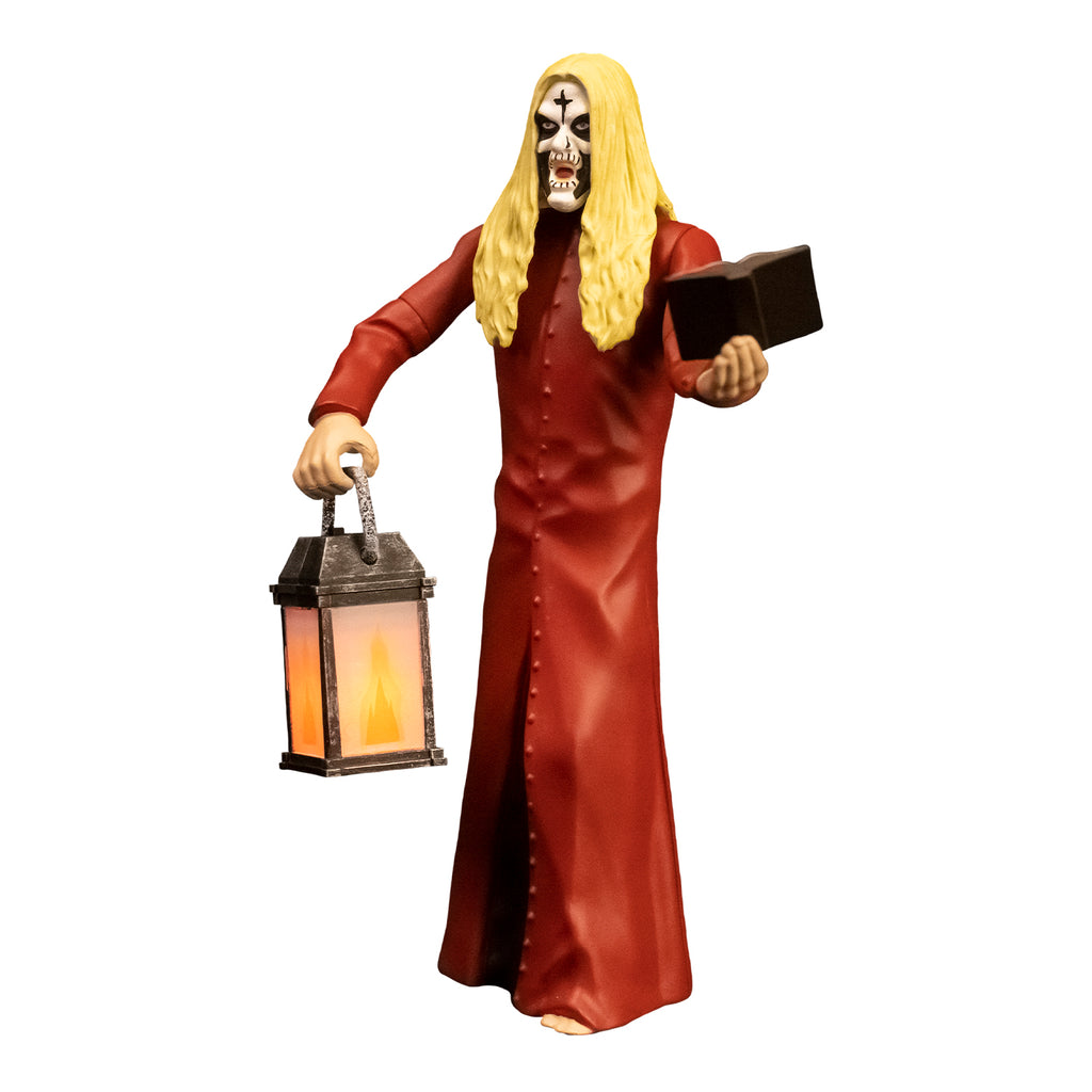 Action figure, left side view. Man, blond hair, white face with black cross on forehead, black around eyes, mouth and cheeks. Wearing floor length red, button down coat, holding book in left hand, lantern in right hand.