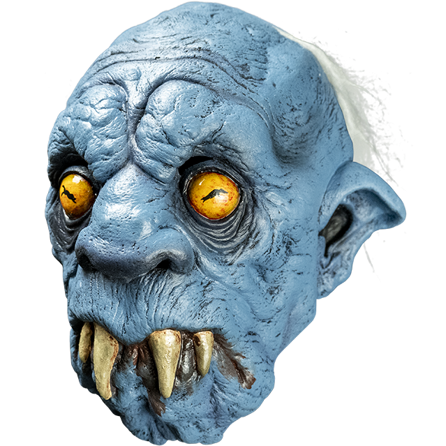 Mask, left view. Creature, mostly bald, wispy white hair on back of head. Wrinkled blue skin. Yellow eyes, pointed ears, large nose. Downturned mouth with 4 large fangs protruding, brown drool.