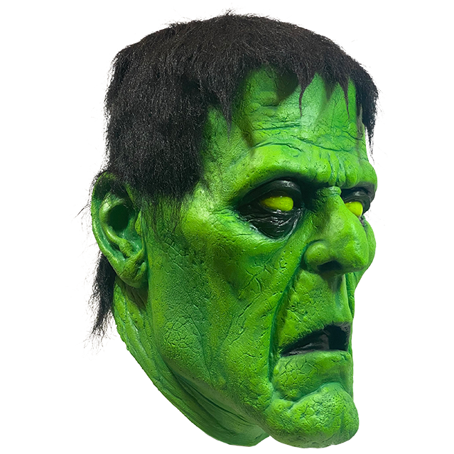 Mask, right side view. Green Frankenstein face, black-rimmed yellow eyes, black hair. mouth open.