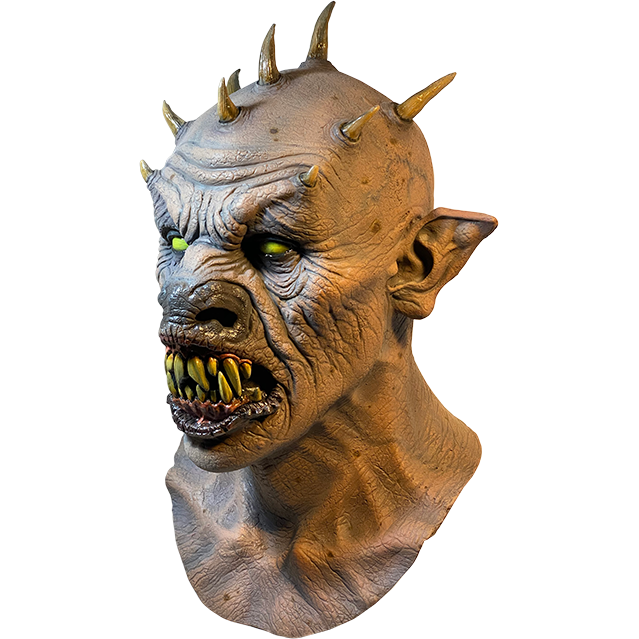 Mask, head and neck, left side view. Bald demon head, 9 spikes on head, wrinkled skin. Large pointed ears, yellow eyes, large snout. open mouth with black lips large sharp yellow teeth.