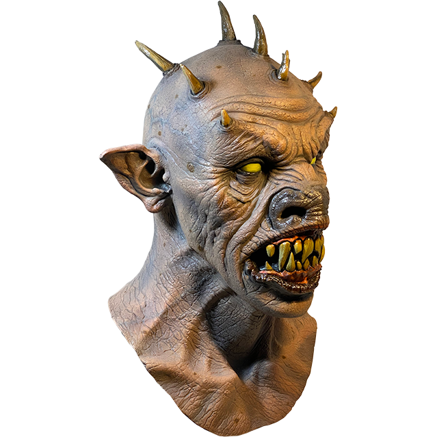 Mask, head and neck, right side view. Bald demon head, 9 spikes on head, wrinkled skin. Large pointed ears, yellow eyes, large snout. open mouth with black lips large sharp yellow teeth.