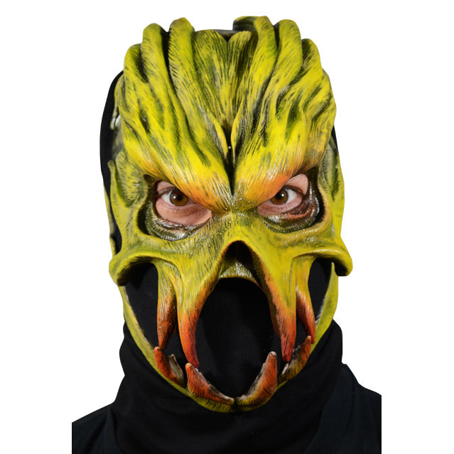 Front view. Man wearing mask, Alien with heavy brows, prominent cheek bones and jaw.  Yellow with hints of orange around eyes and teeth. 