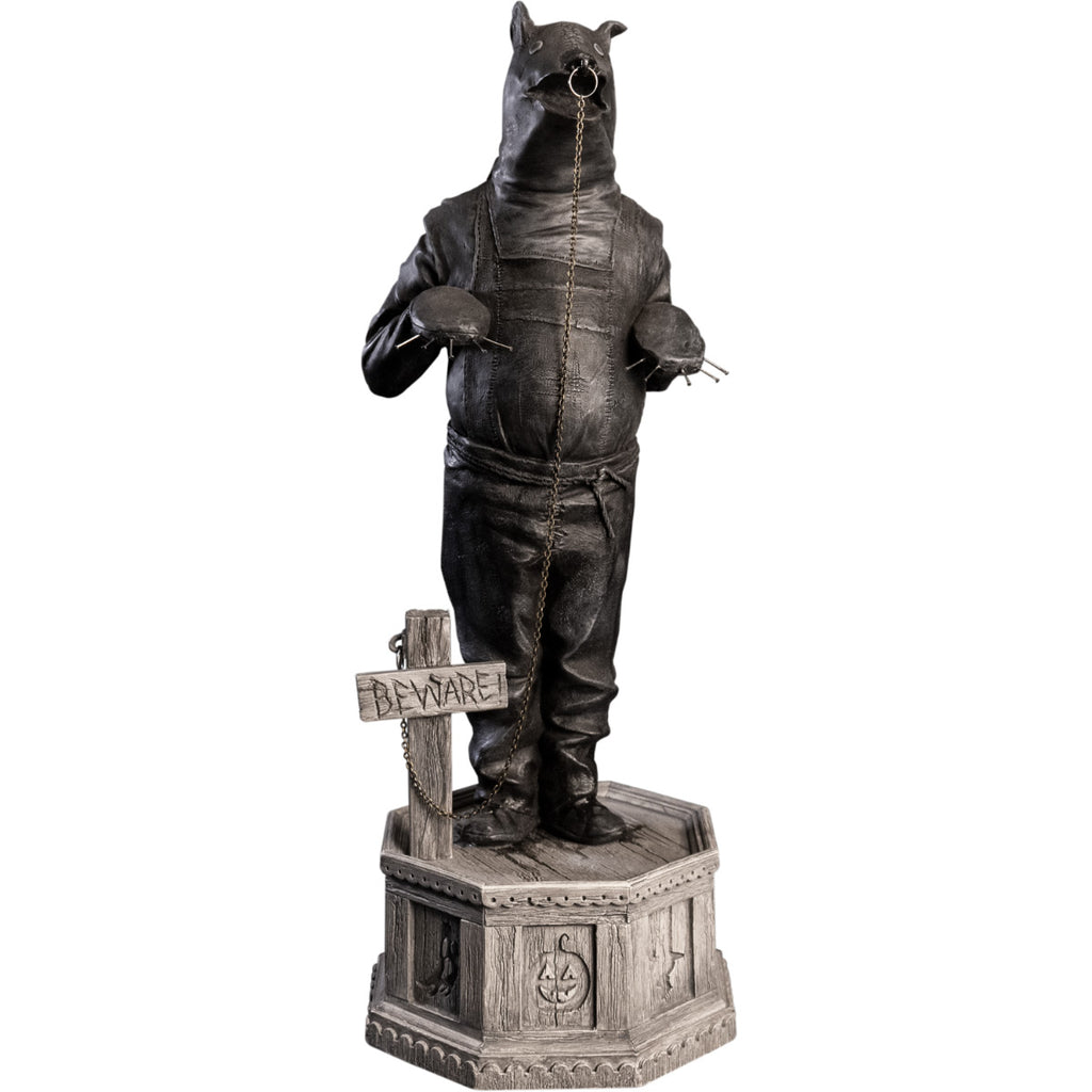 Front view, statue. Grayscale, Person in leather bondage bear costume, with metal claws on hands, ring in nose attached to chain that is attached to a cross, that says Beware, by his feet. Standing on hexagon base made of gravestones.
