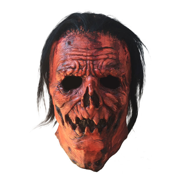 Front view. Jacob Atkins mask. Gory, wrinkled orange Jack o' lantern-like face with stringy black hair.