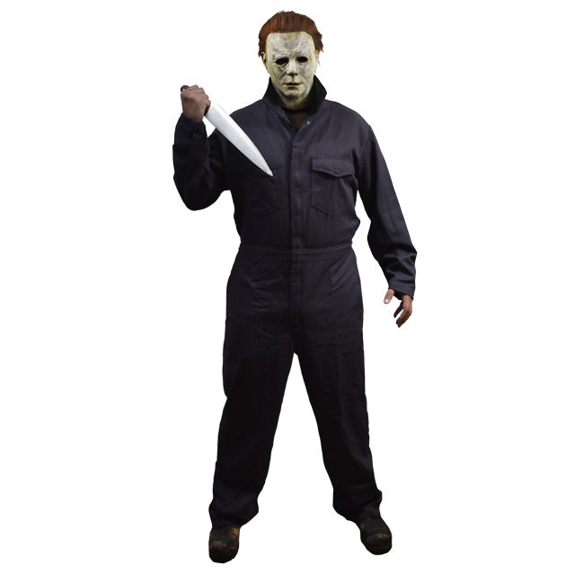 Man in Michael Myers mask and blue coveralls, holding a butcher knife.