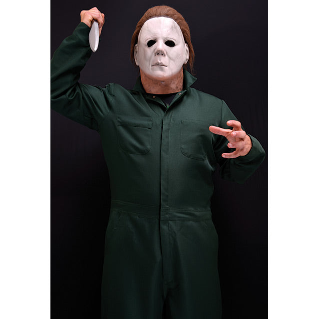 Halloween II - Deluxe Coveralls. Person in Michael Myers mask, black t-shirt, dark green coveralls, holding knife in right hand.