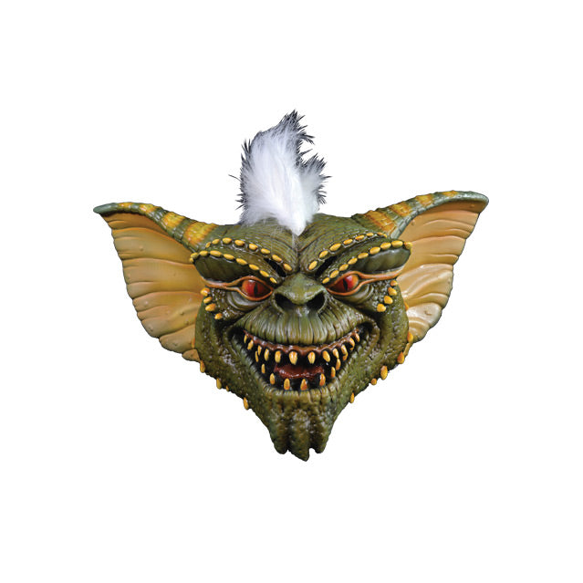 Mask front view.  Green and yellow Gremlin face, orange eyes sharp yellow teeth in grinning mouth, white furry stripe on head.  