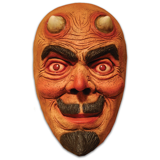 Devil face mask.  Vintage look, reddish face, two small horns on forehead, wrinkled skin on forehead, around eyes and mouth.  Bushy black eyebrows, red eyes, smiling mouth with upturned moustache, goatee.